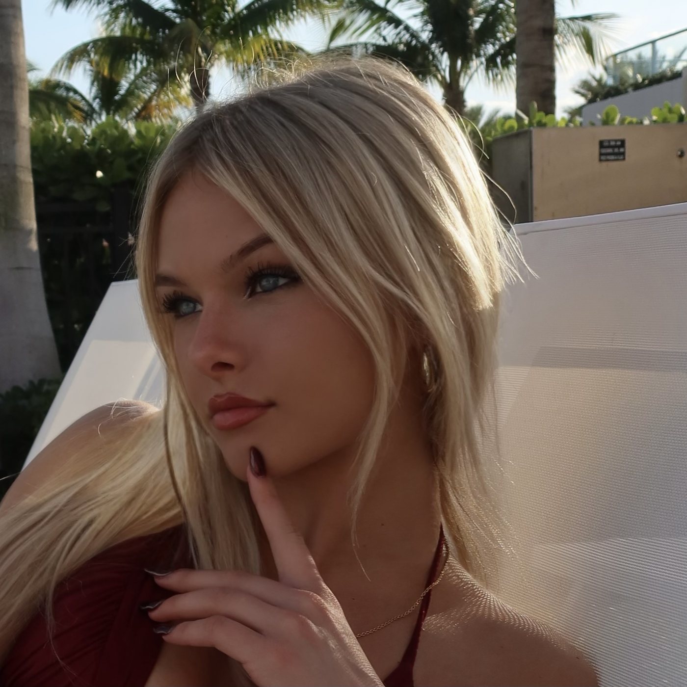 Madeline Grimming on a sun lounger under palm trees